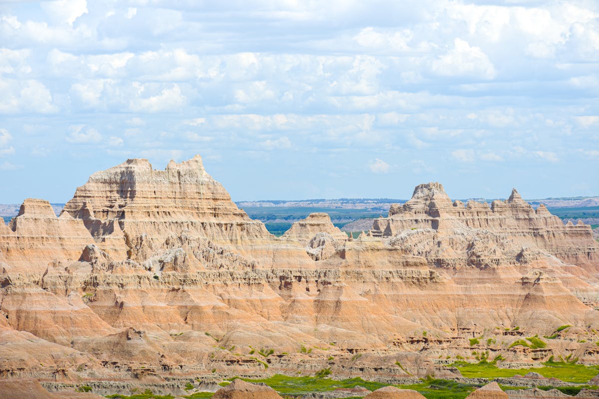 Formations rocheuses stratifiées et buttes dramatiques au parc national Badlands sous le vaste ciel du Dakota du Sud
