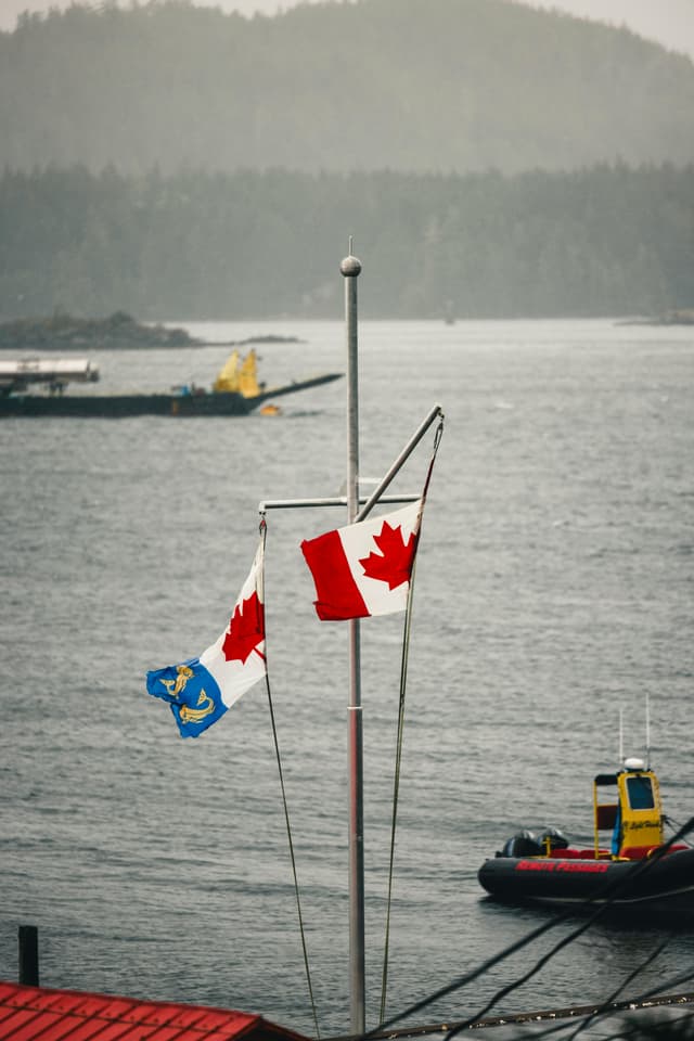 Drapeaux canadiens surplombant le port de Tofino avec vue panoramique pittoresque