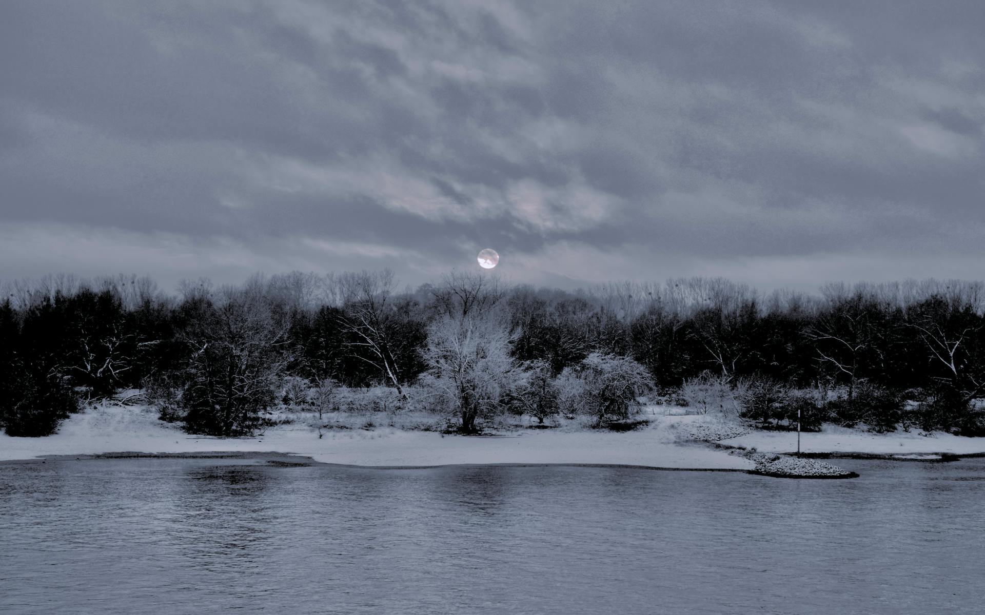 Paysage pittoresque de rivière hivernale au crépuscule avec rives enneigées et réflexions d'eau paisibles