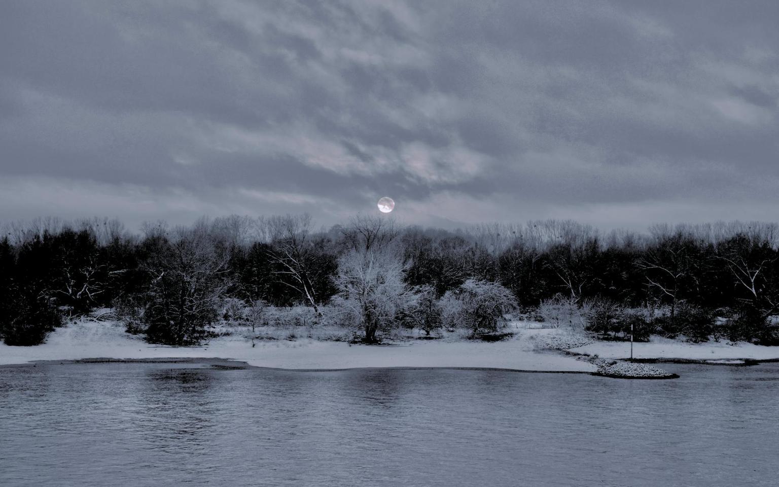 Serene winter river landscape at twilight with snowy banks and peaceful water reflections